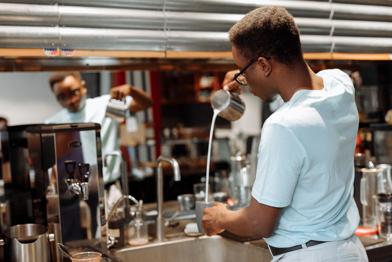 A barista pouring a latte at the espresso bar
